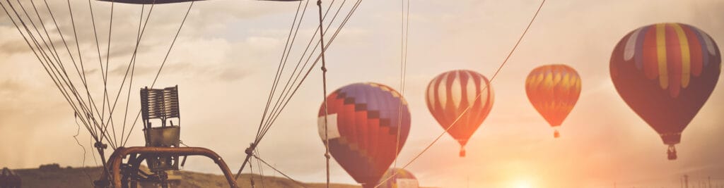 Hot air balloons rising at sunset